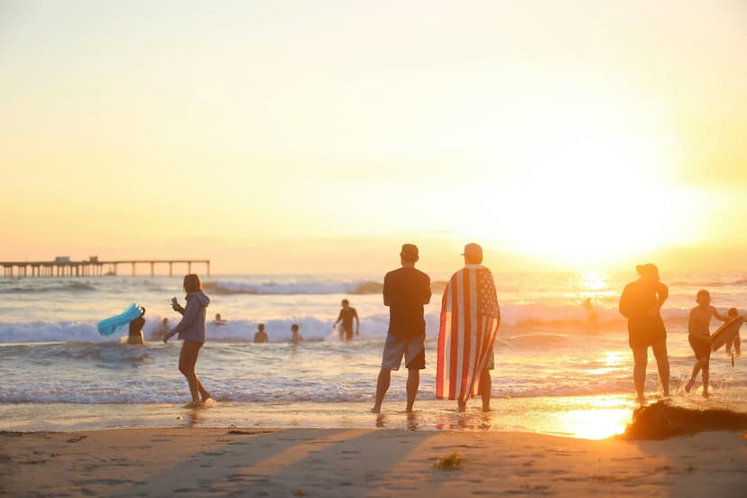 Personnes sur la plage de San Diego au coucher du soleil pendant un séjour linguistique aux États-Unis.